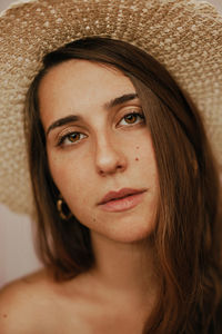 Close-up portrait of beautiful woman wearing hat