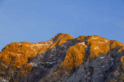 Low angle view of rock formations against clear blue sky
