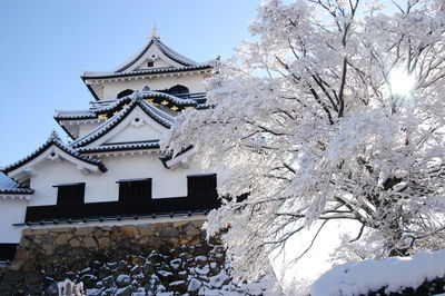 Low angle view of traditional building against sky during winter