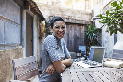 Portrait of smiling businesswoman sitting at table in workshop