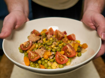 Close-up of person preparing, serving food in plate