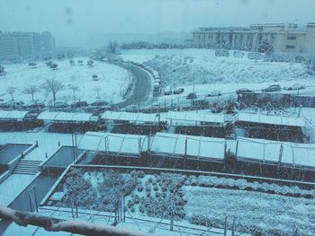 High angle view of snow covered city against sky