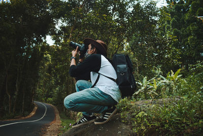Rear view of woman photographing outdoors