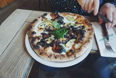 Close-up of hand in plate on table