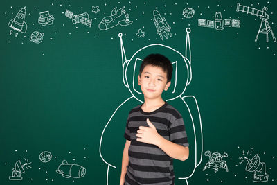 Portrait of smiling boy standing against the wall