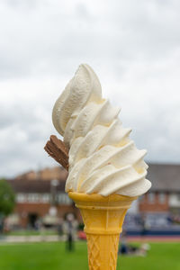 Close-up of ice cream cone against sky