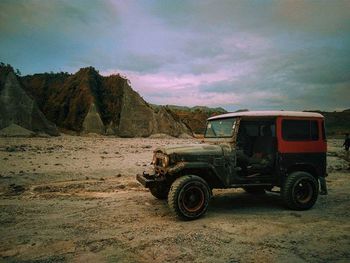 Vintage car on land against sky