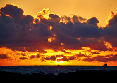 Scenic view of dramatic sky over sea during sunset