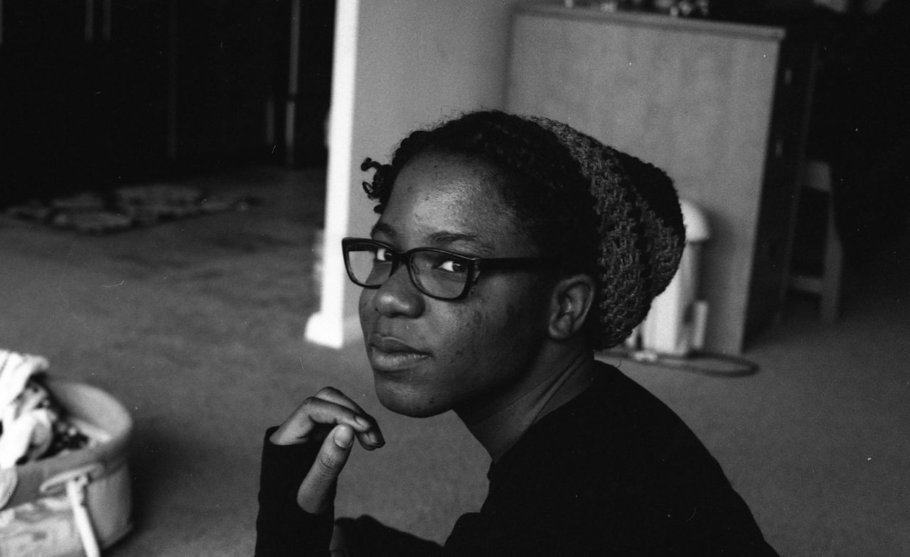 CLOSE-UP OF YOUNG WOMAN WEARING EYEGLASSES