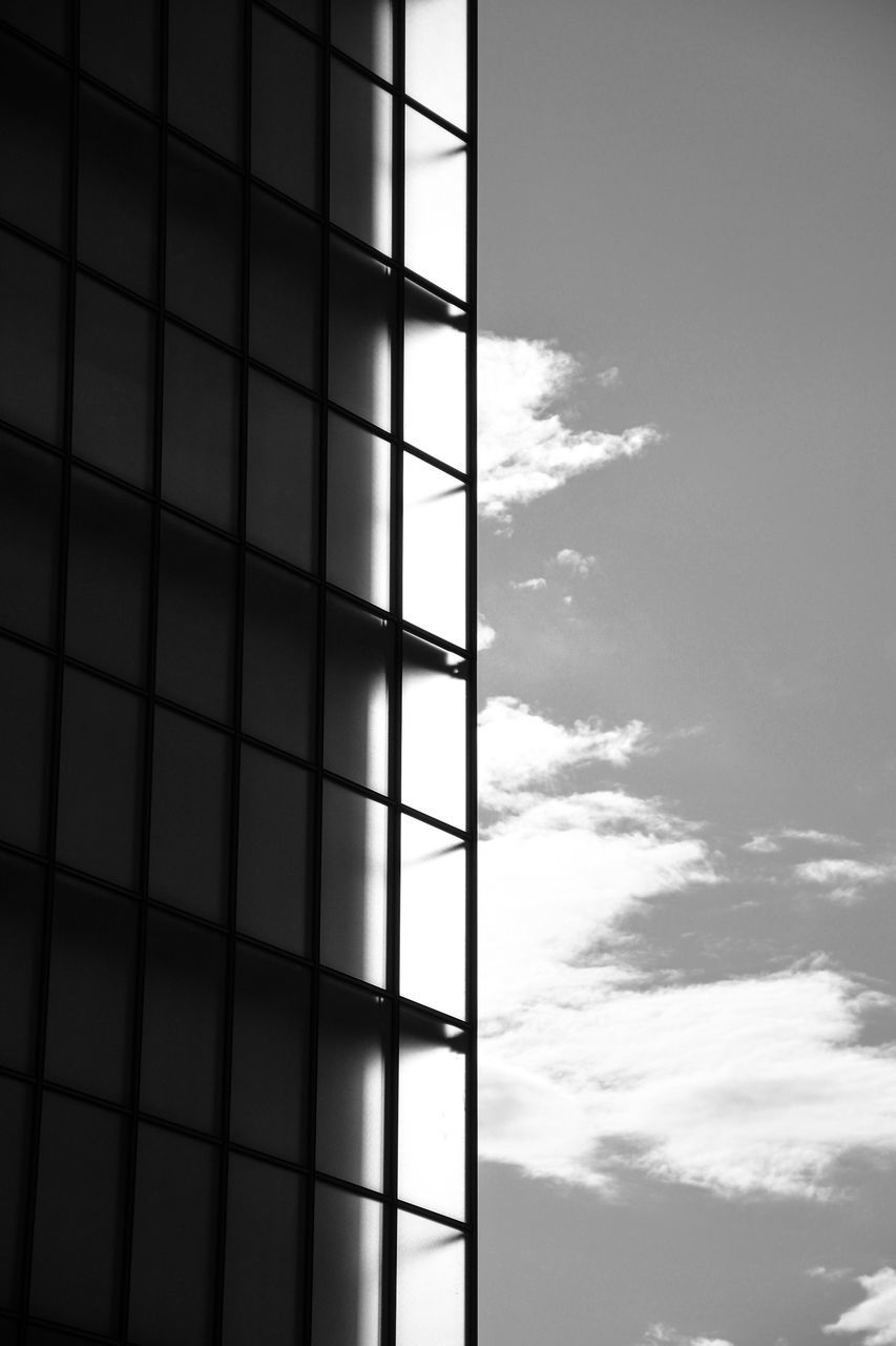 LOW ANGLE VIEW OF MODERN GLASS BUILDING AGAINST SKY