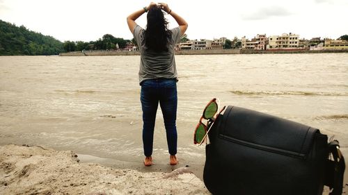 Rear view of woman standing on beach