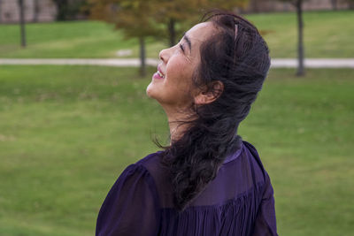 Rear view of woman sitting by pond at park