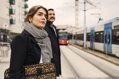 Young woman and man waiting for tram at station