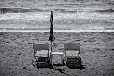 Chairs on beach against sky