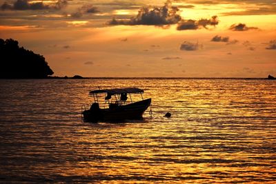 Boat sailing in sea against sky during sunset