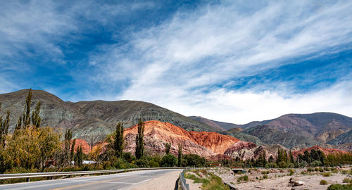 Road by mountains against sky