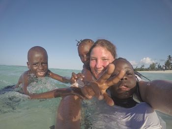Portrait of happy friends against sea