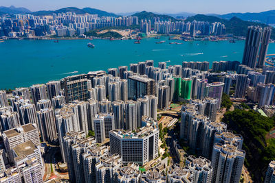 Aerial view of city by sea against sky