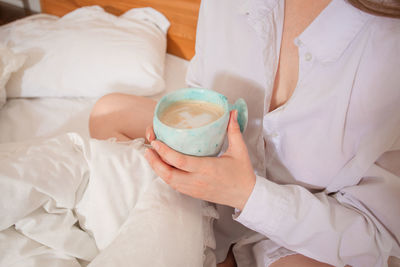 High angle view of man drinking glass on bed