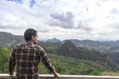 Man standing on mountain against sky