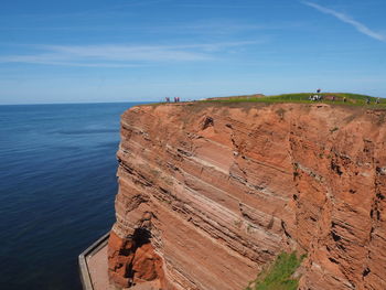 Rock formations by sea against sky