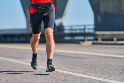 Low section of man running on road