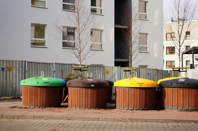 Empty chairs by street against buildings in city