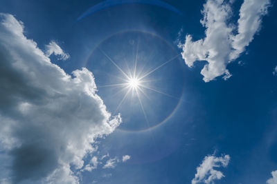 Low angle view of bright sun in sky