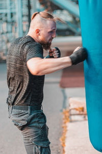 Side view of boxer punching bag in club