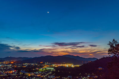 Illuminated cityscape against sky at night