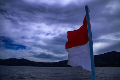 Red flag on mountain against sky