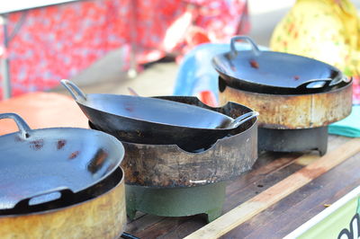 Close-up of cooking pans on stoves outdoors