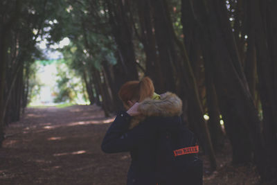 Rear view of woman with backpack in forest