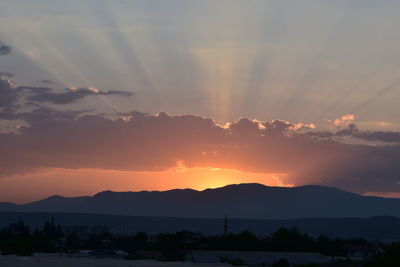 Scenic view of silhouette mountains against romantic sky at sunset