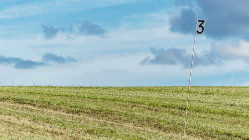 Golf course countryside field with flag and clear blue sky