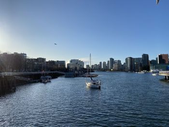 Scenic view of false creek and buildings against clear sky