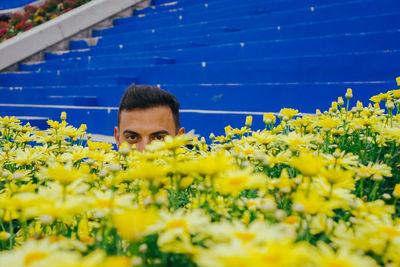 Portrait of man with yellow flowering plants