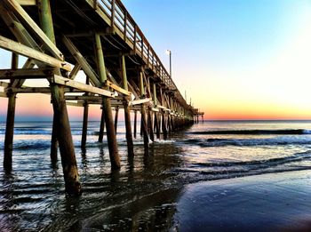 Pier over sea against sky at sunset