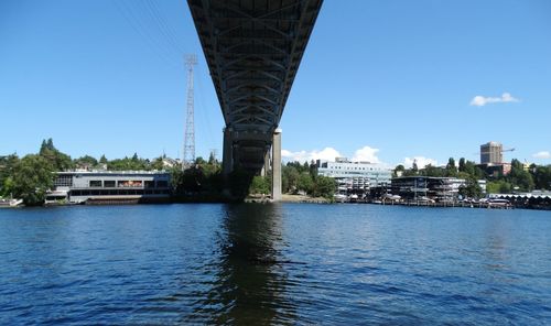 Bridge over river in city against sky