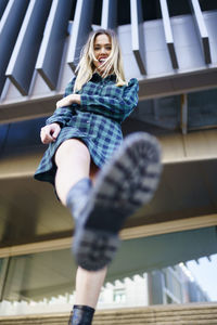 Low angle view of woman sitting outdoors