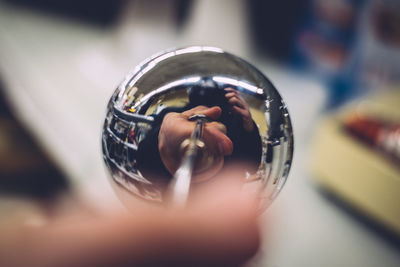 Reflection of man on stainless steel sphere