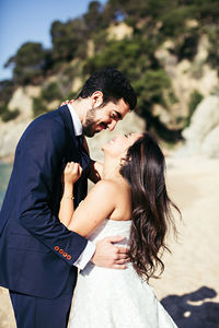 Newlywed couple enjoying at beach during sunny day