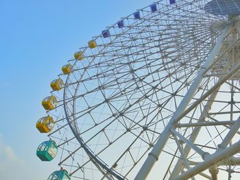 Low angle view of ferris wheel against clear blue sky