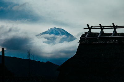 Low angle view of mountain range against cloudy sky