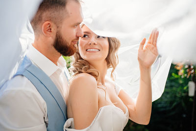 Close-up of bridegroom embracing outdoors
