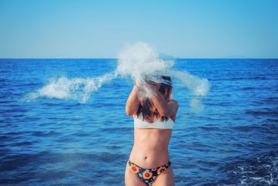 Woman playing with sand at beach