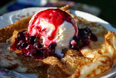 Close-up of pancake with ice cream and preserves in plate