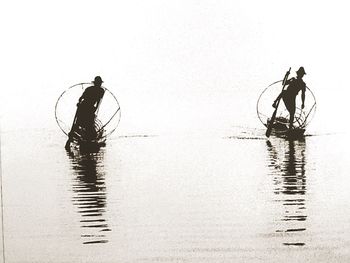 Fishermen fishing in lake