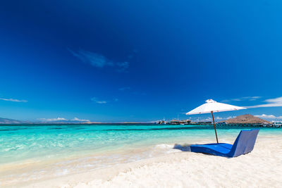 Scenic view of beach against blue sky