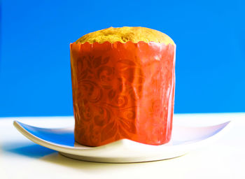 Close-up of cake served on table against blue background